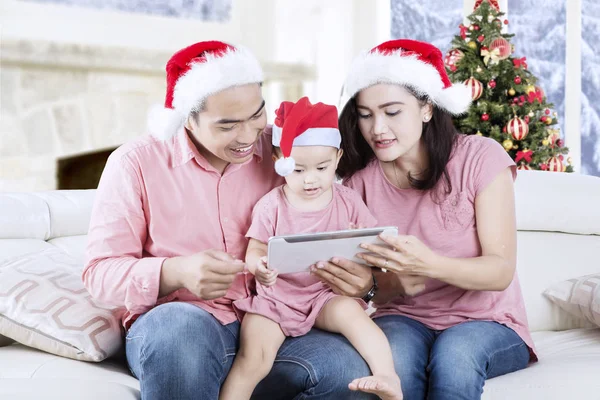 Young family with tablet and Santa hat — Stock Photo, Image