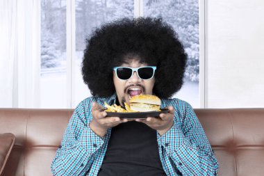 Komik Afro man bir cheeseburger yemek