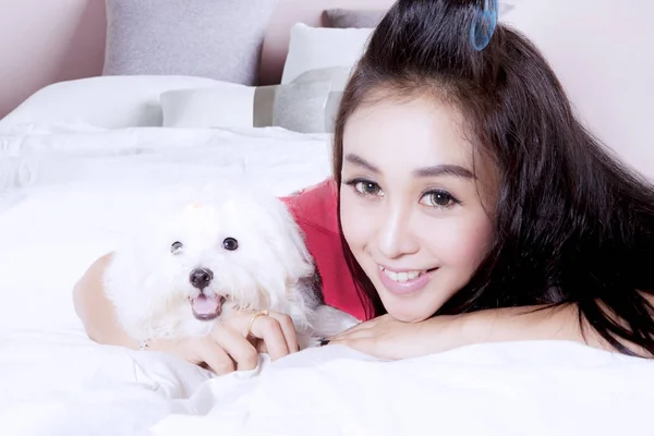 Jolie femme avec chien mignon sur le lit — Photo
