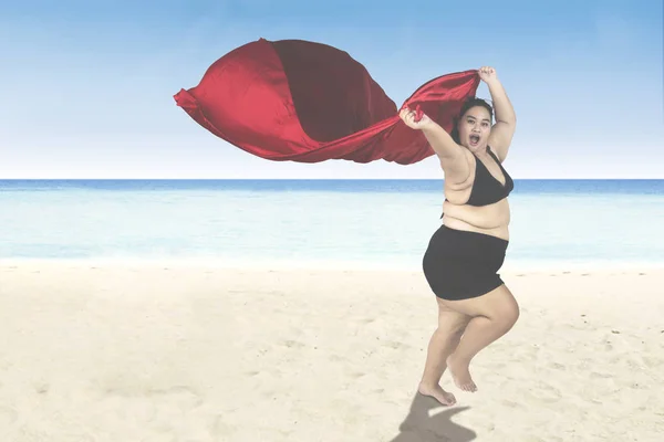 Nadwagę kobieta działa na plaży — Zdjęcie stockowe