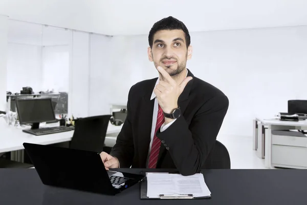 Bonito homem de negócios pensando no local de trabalho — Fotografia de Stock