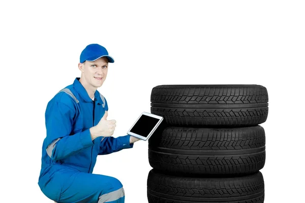 European mechanic shows thumb up near tires — Stock Photo, Image