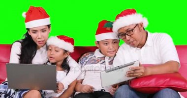 Aile ile Noel Baba şapkası kullanın dizüstü ve tablet