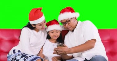 Neşeli Noel Baba şapkası ailesiyle kullanma smartphone