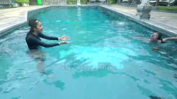 Frau lehrt ihre Tochter am Pool schwimmen — Stockvideo
