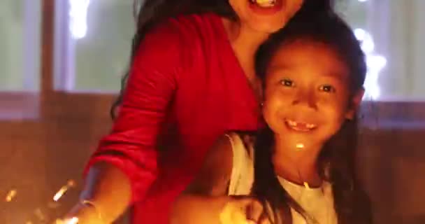 Toothless girl and mother playing burning sparkler — Stock Video