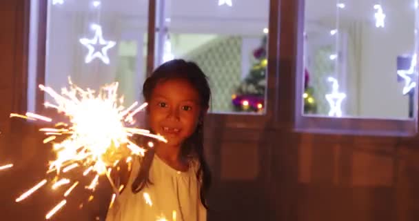小さな女の子が遊んでクリスマス花火自宅 — ストック動画