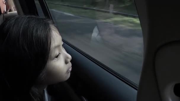 Liten flicka tittar genom bilfönstret — Stockvideo