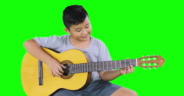 Menino aprende a tocar guitarra no estúdio — Vídeo de Stock