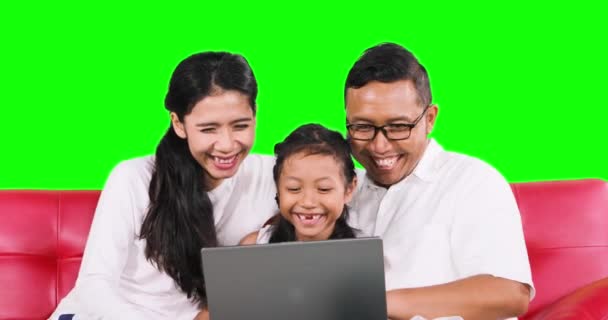 Toothless girl and parents use laptop on sofa — Stock Video