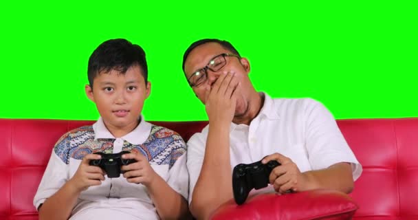 Tired father and his son playing video game — Stock Video