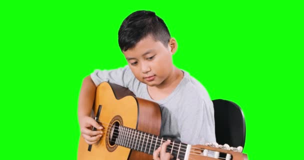 Красивый маленький мальчик играет на гитаре в студии — стоковое видео