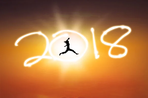 Молодая женщина прыгает с номером 2018 — стоковое фото
