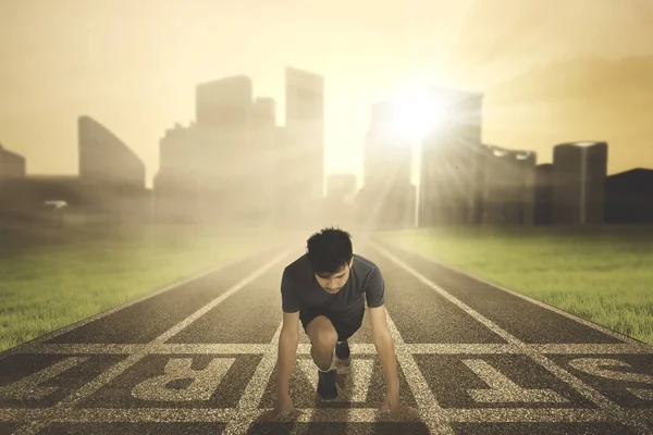 Young man kneeling on the start line — Stock Photo, Image