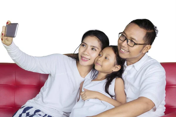 Jovem família tirando uma foto juntos no estúdio — Fotografia de Stock