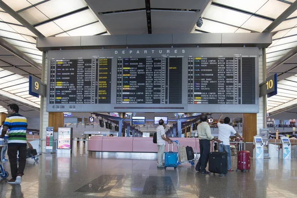 Os viajantes verificam o horário de voos em Changi Aeroporto — Fotografia de Stock