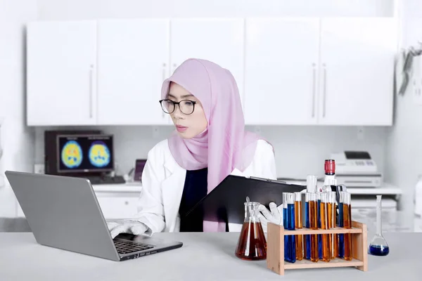 Muslimska kemist med laptop och Urklipp — Stockfoto