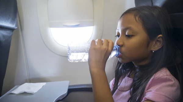 小女孩在飞机上喝水 — 图库照片