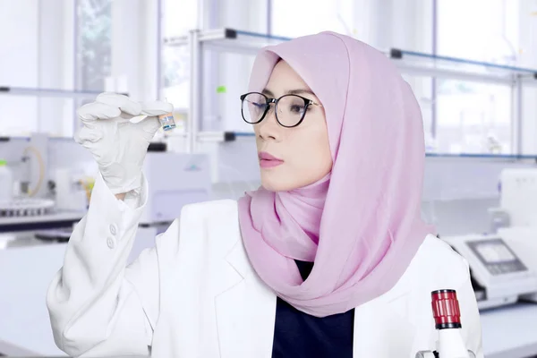 Kvinnliga forskare håller en liten flaska — Stockfoto