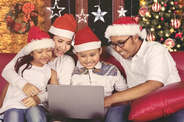 Neşeli aile Noel günü bir dizüstü bilgisayar kullanarak — Stok fotoğraf