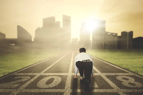 Empresario listo para correr hacia una ciudad — Foto de Stock