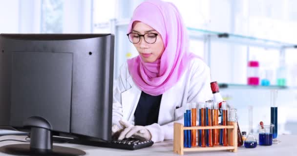 Científico musulmán con computadora y sonriendo — Vídeos de Stock