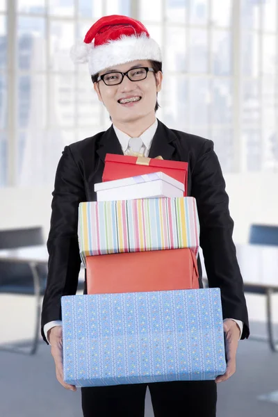 Young businessman with Christmas gifts — Stock Photo, Image