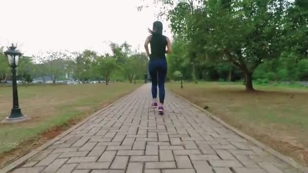 Mujer joven corriendo en el parque — Vídeo de stock