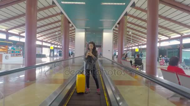 Mulher em pé na passarela em movimento no aeroporto — Vídeo de Stock