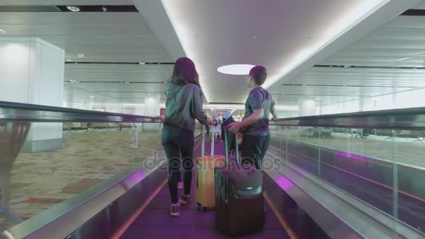 Woman and her children standing on travelator — Stock Video