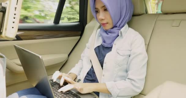 Muslim woman using laptop in car — Stock Video