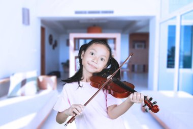 Küçük kız evde keman çalıyor