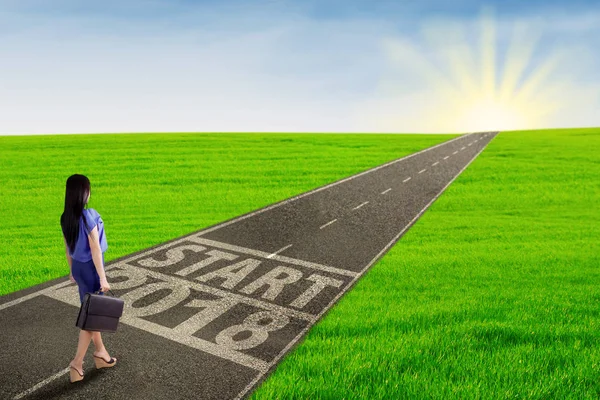 Young businesswoman walking toward the sunlight — Stock Photo, Image