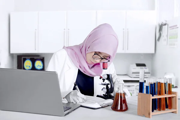 Μουσουλμανική ερευνητής που εργάζεται με μικροσκόπιο — Φωτογραφία Αρχείου