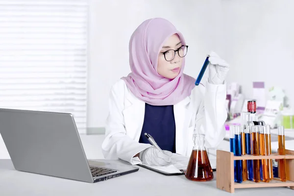Muslim doctor checking test tube