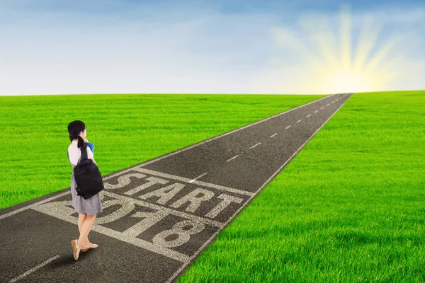 Female student walking above text of start 2018 — Stock Photo, Image