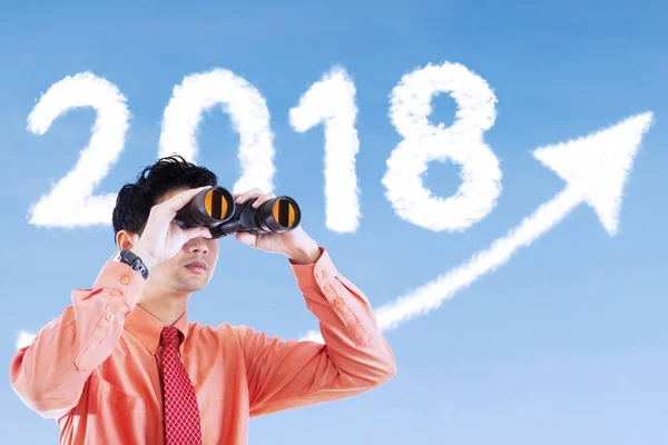 Empresário olha para o número 2018 com binocular — Fotografia de Stock