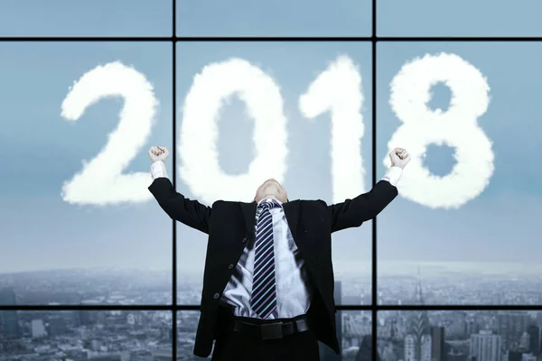 Empresário asiático com nuvens em forma de números 2018 — Fotografia de Stock