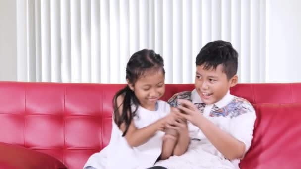 Двое Злых Детей Дерутся Пытаются Использовать Мобильный Телефон Диване Гостиной — стоковое видео