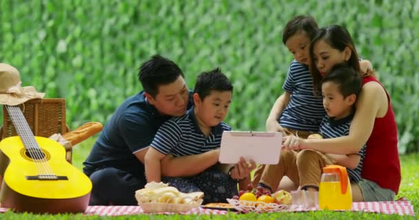 Lycklig Familj Använder Digital Surfplatta Medan Picknick Tillsammans Och Sitter — Stockvideo