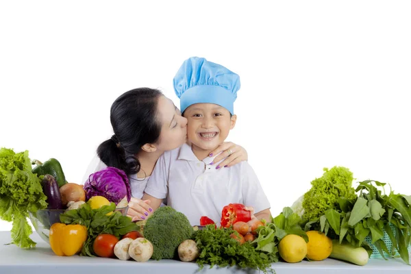 Jovem mãe beijando seu pequeno chef — Fotografia de Stock