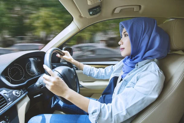 Mulher muçulmana dirigindo um carro na estrada — Fotografia de Stock