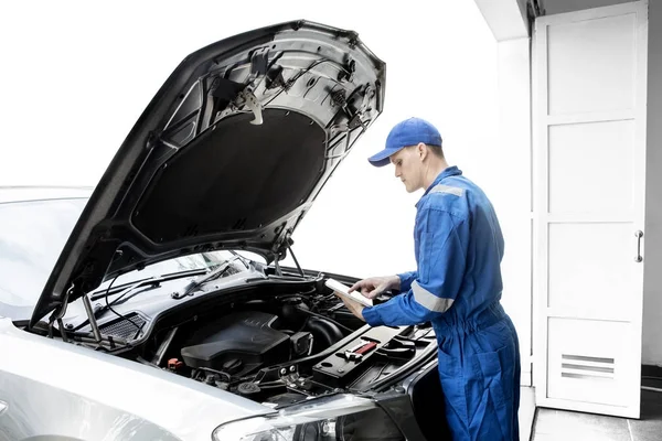 Amerykański mechanik naprawy samochodu z tabletem — Zdjęcie stockowe