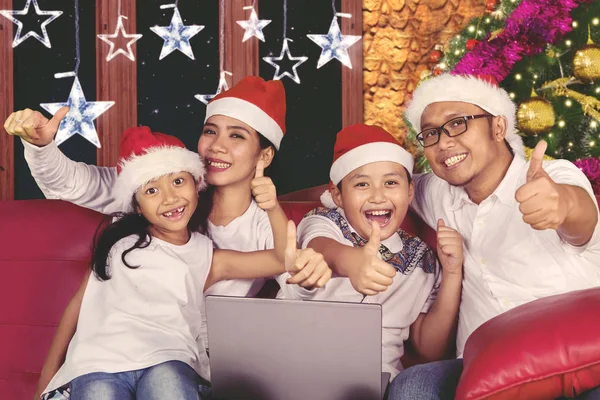 Familia joven usando un portátil en Navidad —  Fotos de Stock