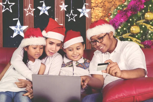 Jeune famille faisant du shopping en ligne à Noël — Photo