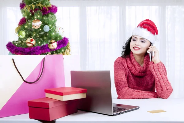 Femme achetant des cadeaux de Noël avec un smartphone — Photo