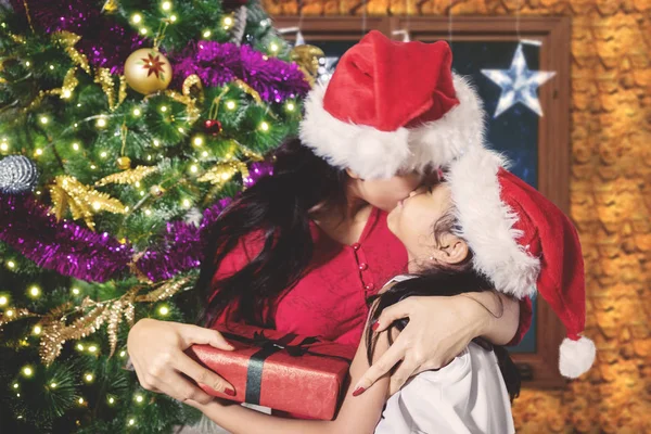 Moeder gekust door haar dochter bij Kerstmis — Stockfoto