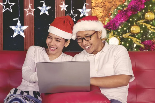 Lyckligt par använder en bärbar dator i juletid — Stockfoto