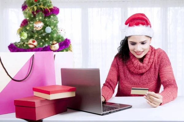 Belle femme détient une carte de crédit près de l'arbre de Noël — Photo