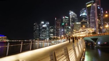 Singapur - 27 Kasım 2017: Gökdelenler Peyzaj ve gece kalabalık yaya güzel timelapse Esplanade Köprüsü Singapur'dan. 4 k çözünürlükte vurdu